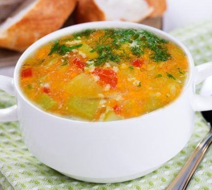 Ciorbă de dovlecel a la grec în bol alb, alături de pâine și verdeață