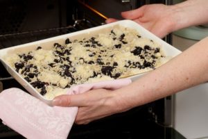 Pasul de introducere la cuptor a tăvii cu Prăjitură cu afine și crumble cu migdale