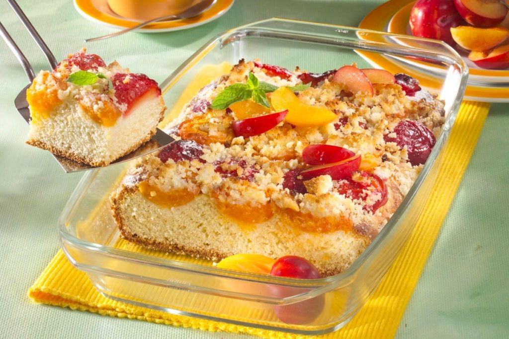 Prăjitură cu prune și caise, acoperite cu crumble crocant, în forma de copt de sticlă