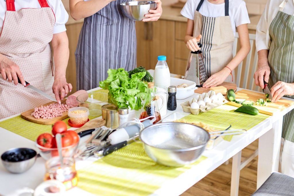 O familie în bucătărie, pregătind prparate și ținând cont de cele 10 trucuri în bucătărie