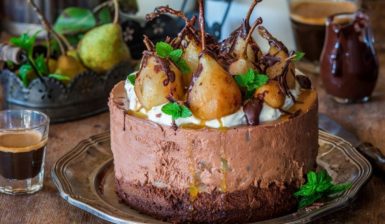 Tort cu mousse de ciocolată și pere poșate în vin roșu, pe un platou de servire
