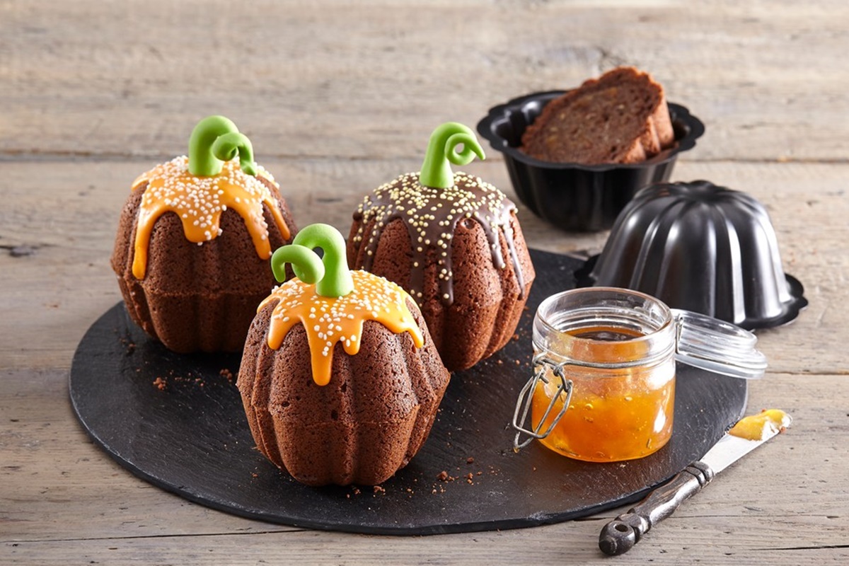Muffins fantezie sub formă de dovleac, decorați cu glazură icing galbenă și ciocolată topită