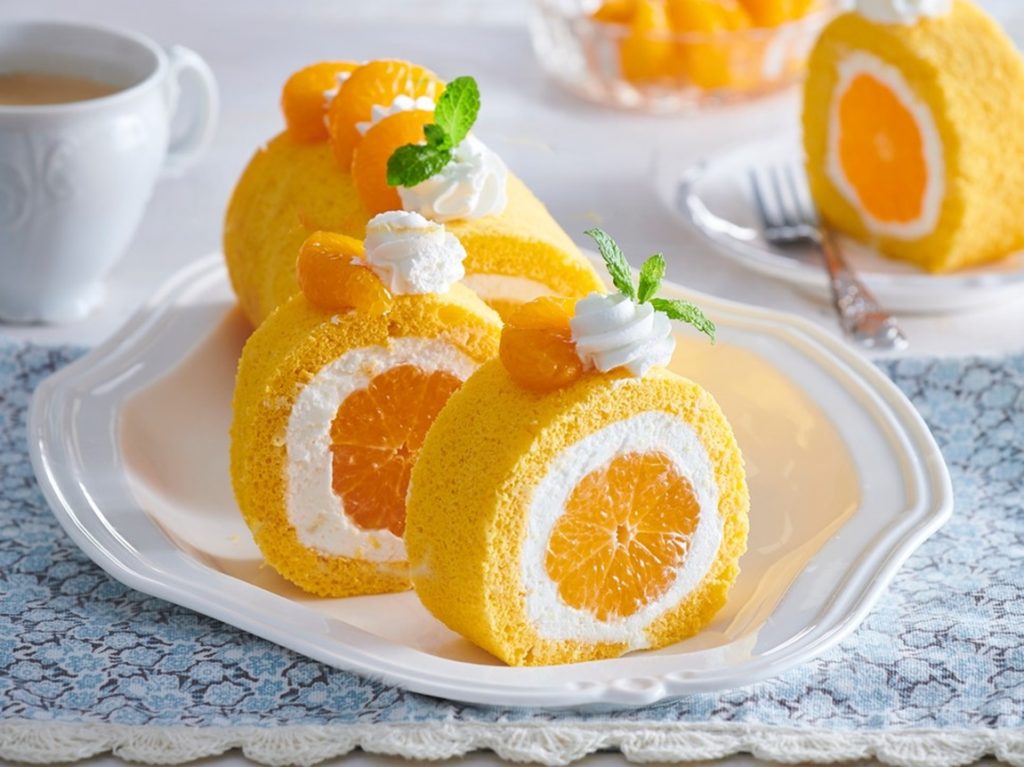 Ruladă cu portocale și cremă de mascarpone porționată pe un platou de servire