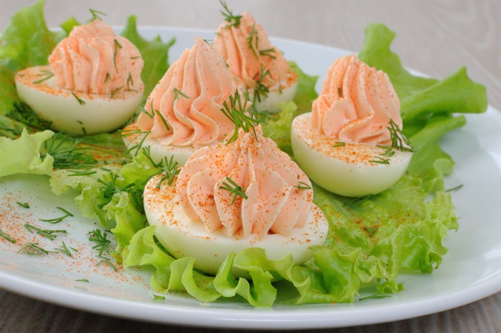 Ouă umplute cu pate de somon pe frunze de salată verde