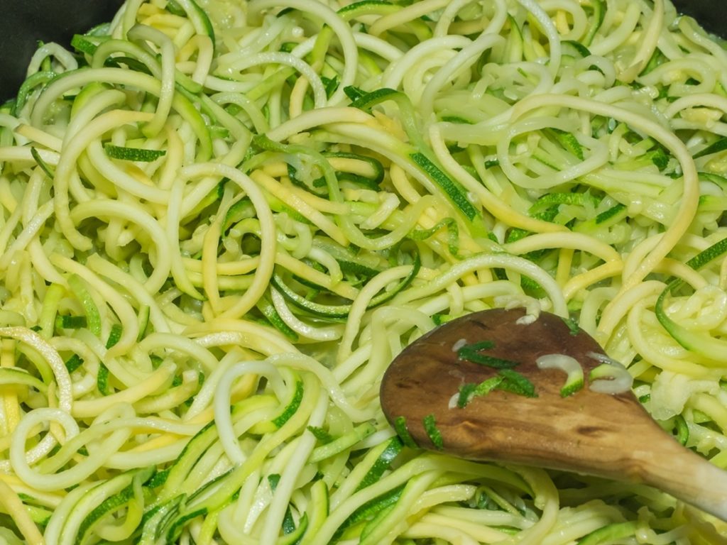 Pasul de amestecare a spaghetelor de dovlecei în tigaie