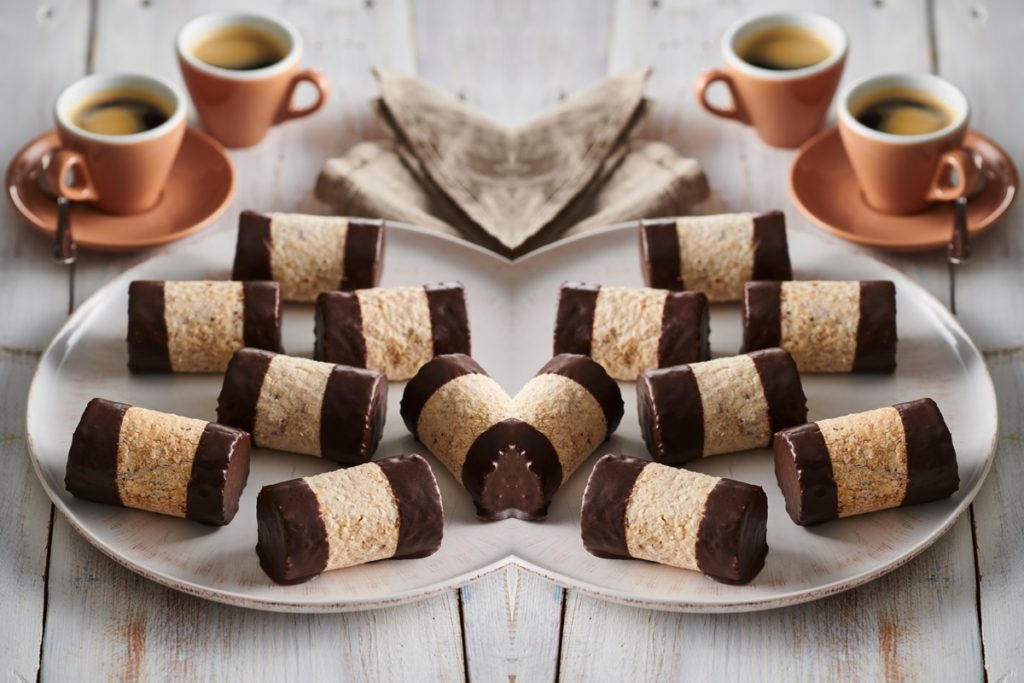 Rulouri de bezea cu ciocolată pe un platou, alături de cești cu cafea - Rețete de prăjituri din albușuri