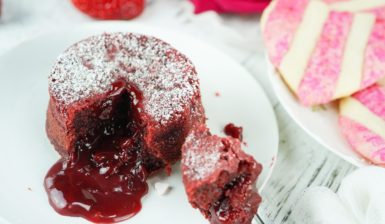 Porție de Red Velvet Lava Cake secționată cu furculița pe o farfurie albă