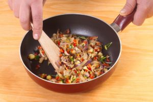 Ciuperci cu legume amestecate în tigaie cu o spatulă