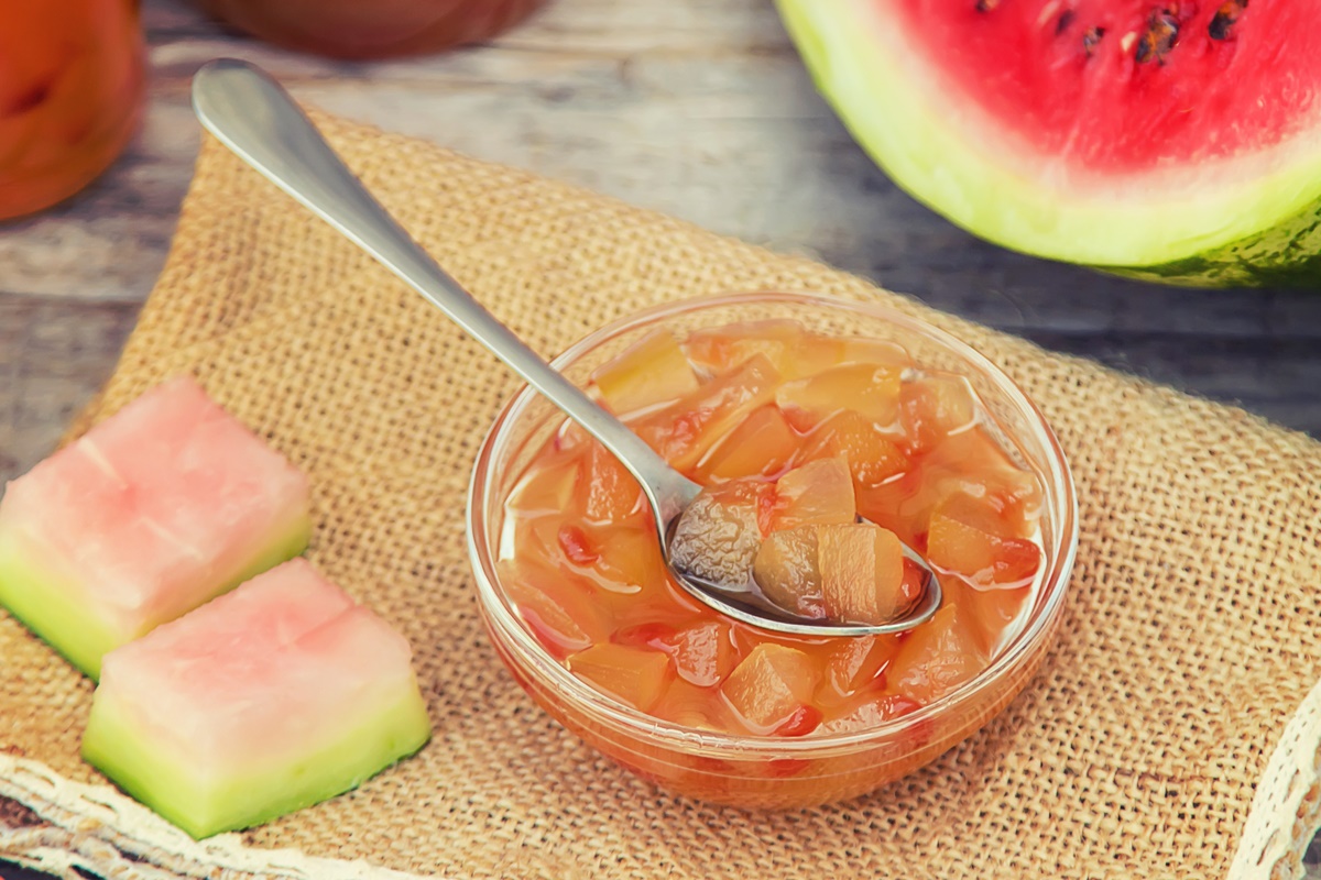 Dulceață din coji de pepene roșu în bol cu linguriță, alături de o felie de pepene / Shutterstock