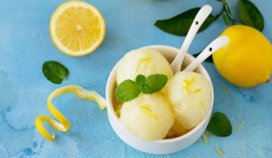 Trei cupe de înghețată cu aromă intensă de lămâie în bol alb cu două lingurițe albe