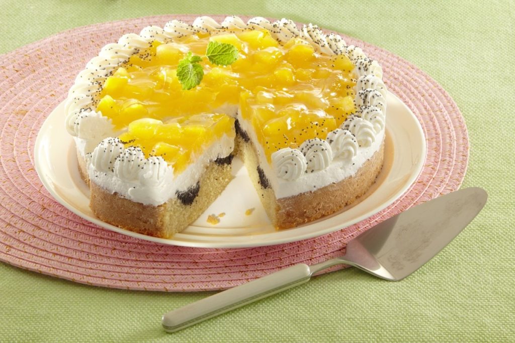 Tort cu compot de dovleac și blat marmorat cu mac porționat pe un platou, alături de o spatulă de tort