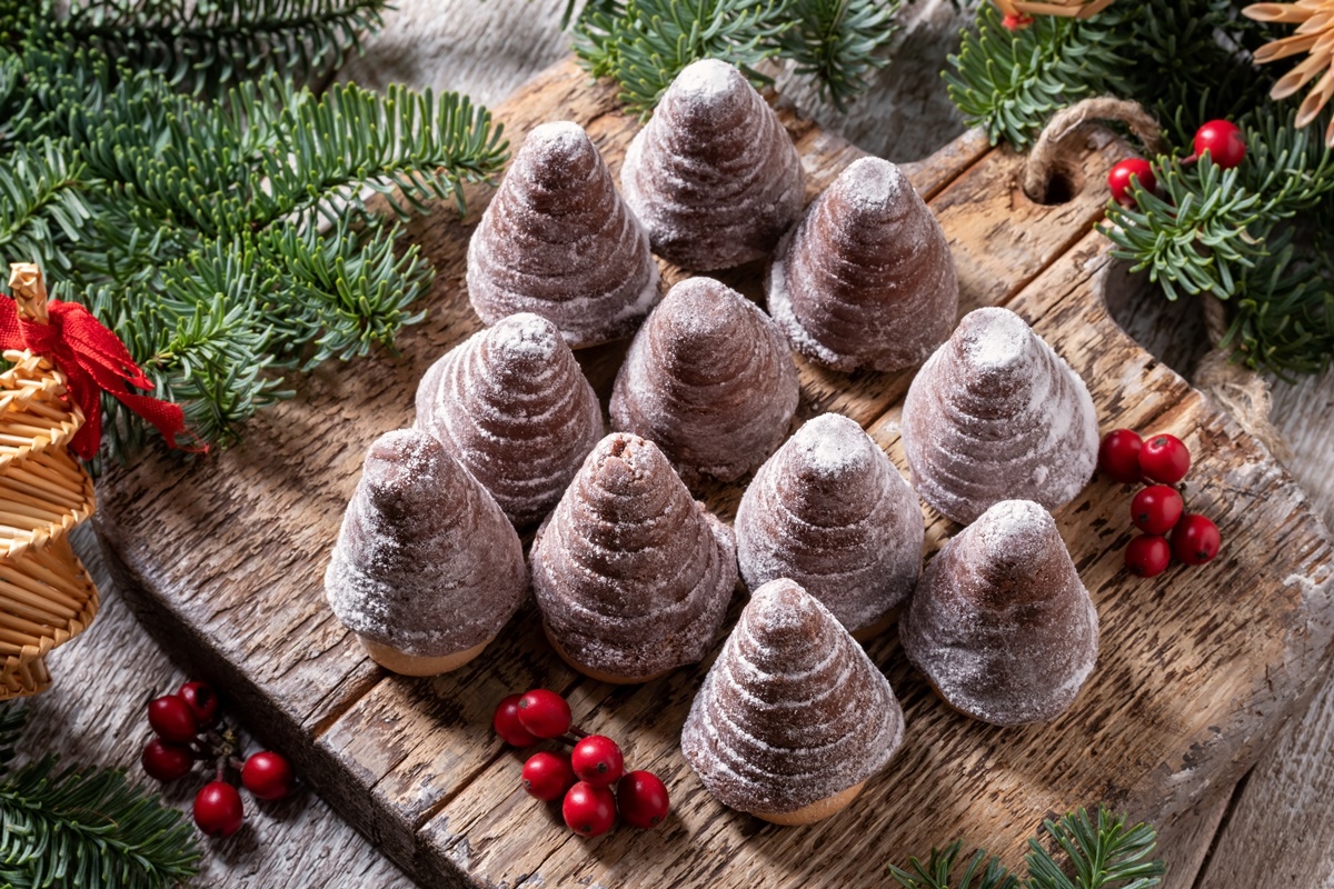 11 brăduți de Crăciun din biscuiți cu sos de ciocolată, pe o masă rustică de lemn, într-un decor de sărbătoare