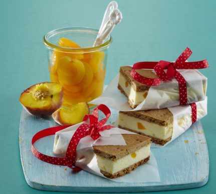 Trei porții de înghețată sandwich cu vanilie și piersici alături de un pahar cu compot de piersici și o piersică feliată