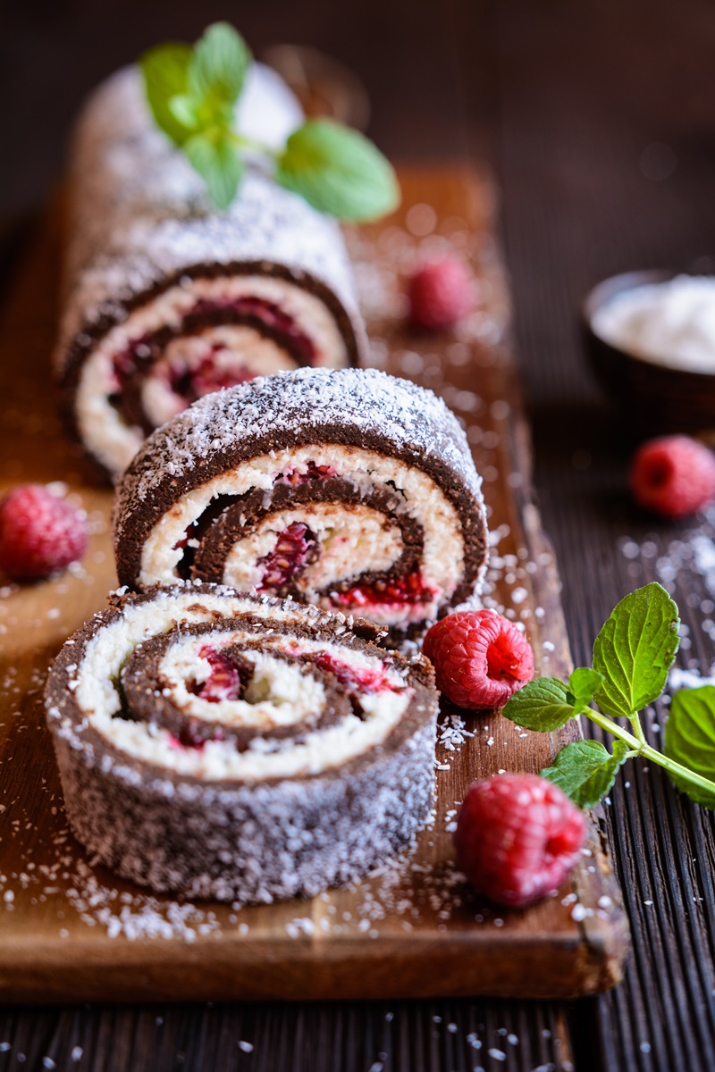 Ruladă fără coacere cu biscuiți, cremă de cocos și zmeură porționată