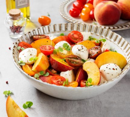 Salată de vară cu roșii, piersici, mini mozzarella și microgreens de busuioc în bol