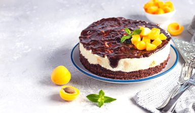 Cheesecake cu caise și glazură de ciocolată, decorat cu caise și frunze de mentă