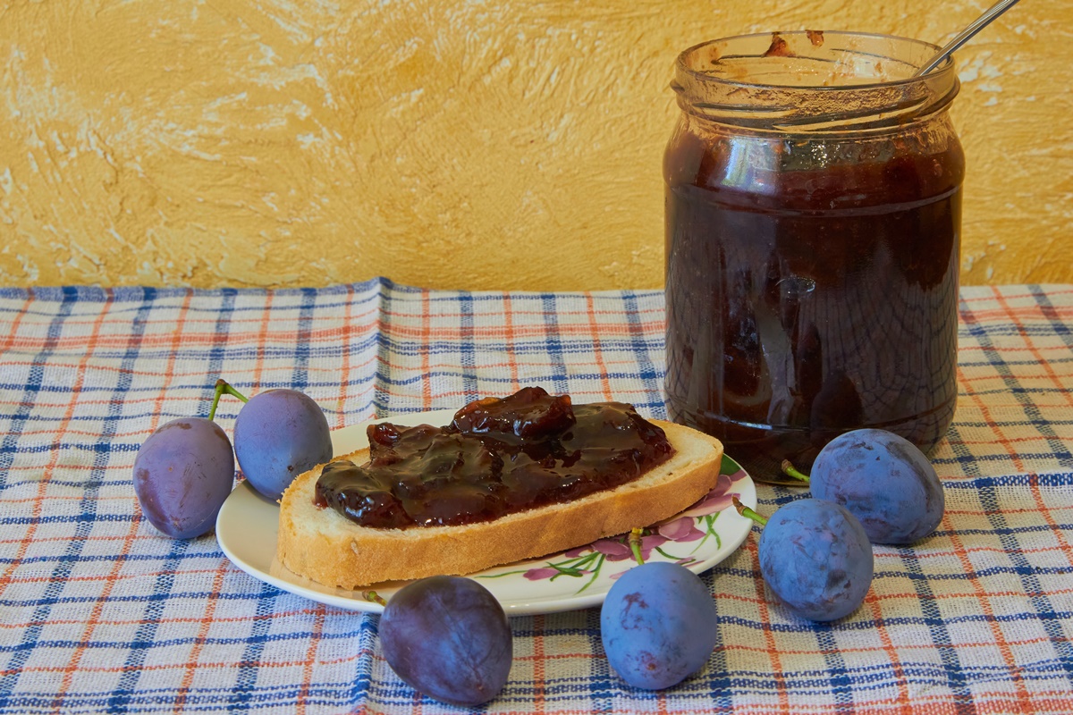 Dulceață de prune jumătăți în borcan și pe felie de pâine