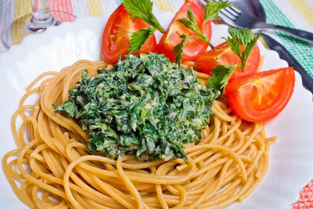 Spaghete cu urzici și usturoi servite cu roșii feliate