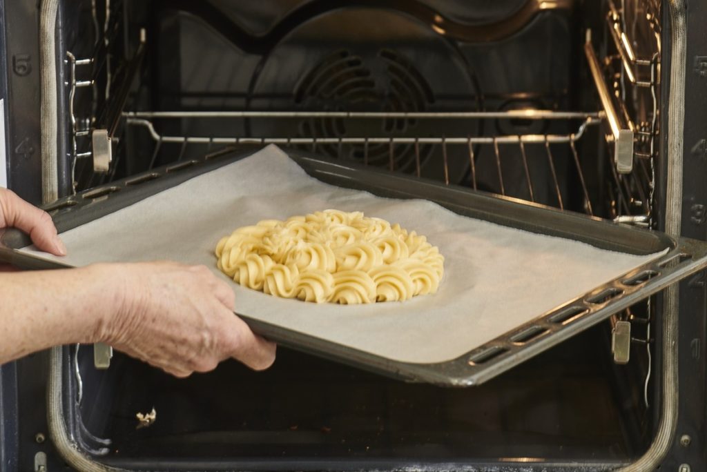 Pasul de introducere în cuptor a tăvii cu blatul de tort