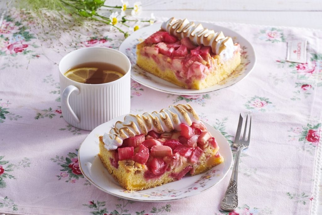 Două porții de pandișpan cu rubarbă și bezea, alături de o ceașcă cu cafea