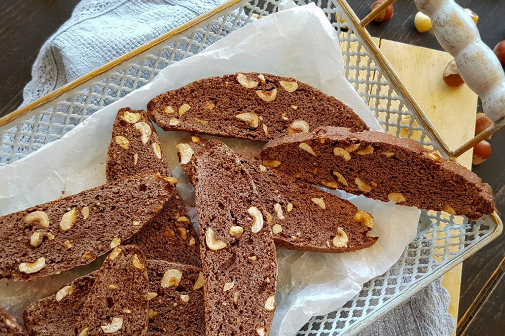 Biscotti cu alune și ciocolată în aluat așezați într-o tavă