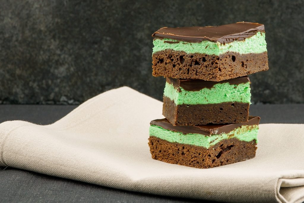 Trei porții de negresă cu unt de arahide, cremă de mentă și glazură de ciocolată pe un ștergar