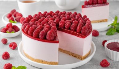 Cheesecake cu jeleu de zmeură secționat pe platou și o porție pe farfurie
