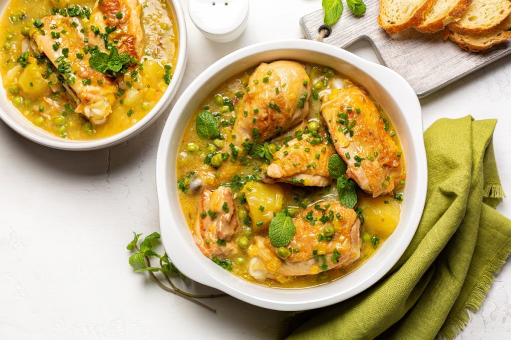 Două porție mâncare de mazăre cu pui și mentă, alături de felii de pâine