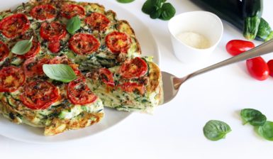 Frittata cu dovlecei și roșii, aromată cu busuioc, porționată pe o spatulă