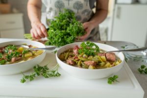 femeie adăugând pătrunjel verde în mâncare