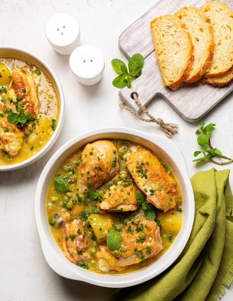 Două porții de pui cu mazăre și mentă, alături de felii de pâine