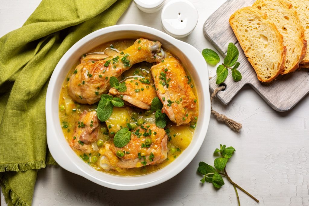 Porție de pui cu mazăre și mentă, alături de felii de pâine