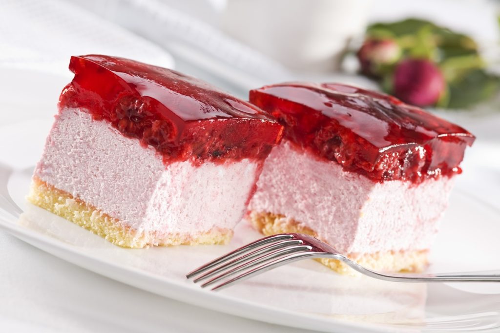 Două porții de prăjitură cu mousse de zmeură și jeleu de zmeură