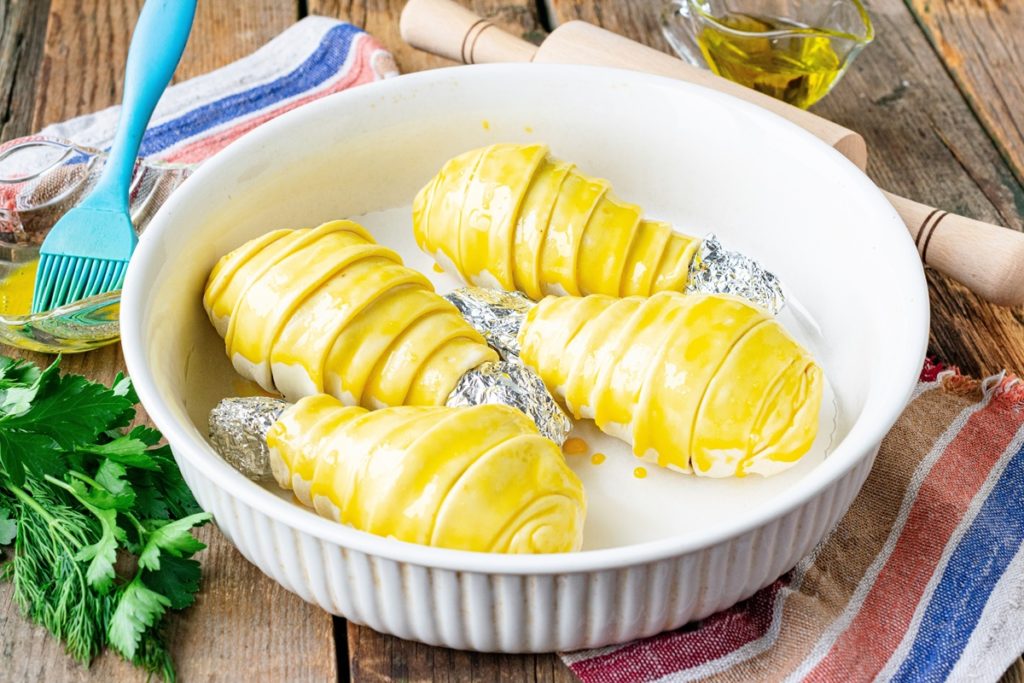 Patru pulpe înfășurate în aluat și unse cu ou, într-un vas alb