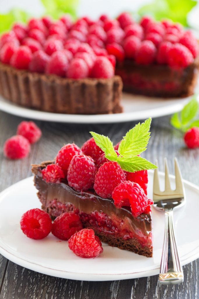 Porție de tartă cu zmeură și cremă de ciocolată