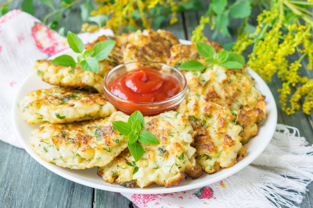 Chiftele vegetale pe un platou și un bol cu sos de roșii