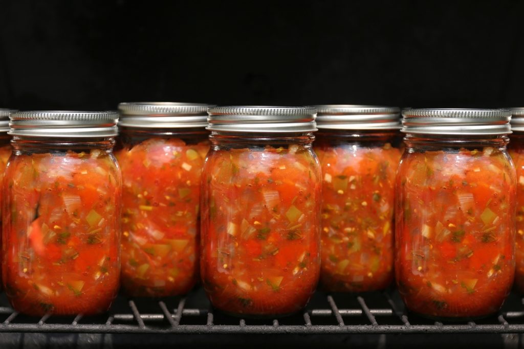 Borcane cu conservă de roșii cu ceapă, ardei și verdeață în cuptor