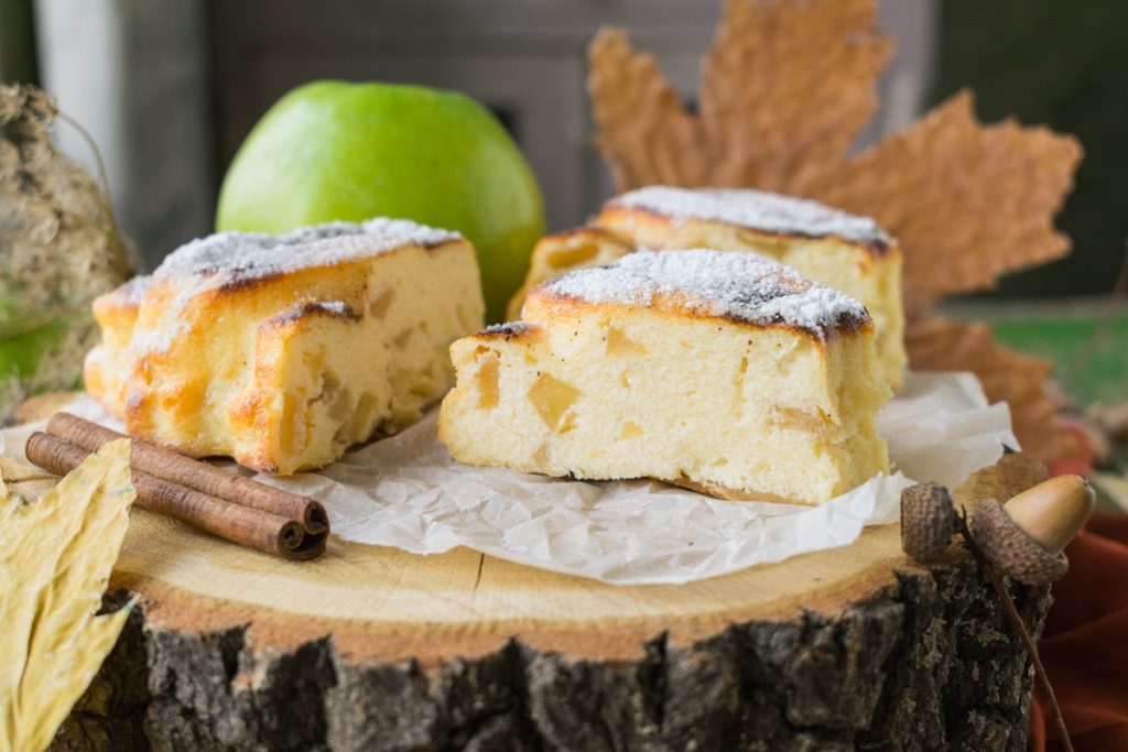 Trei porții de prăjitură cu brânză și mere cuburi și un măr verde