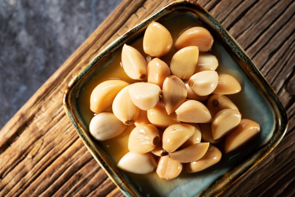 Usturoi macerat în miere într-un bol