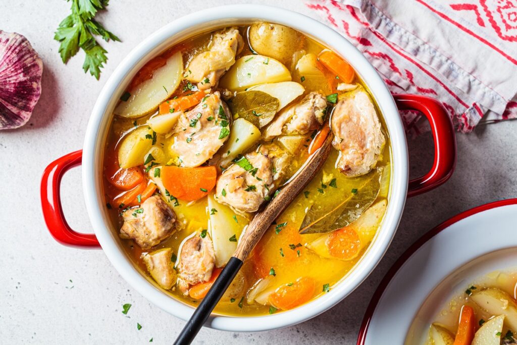 Carne de pui cu cartofi și morcovi în cratiță cu lingură