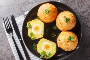 Patru ouă în crustă de cartofi piure, unul secționat