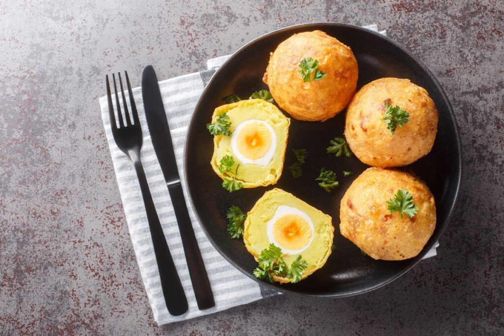 Ouă în crustă de cartofi piure-unul secționat