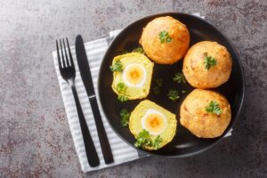 Ouă în crustă de cartofi piure-unul secționat