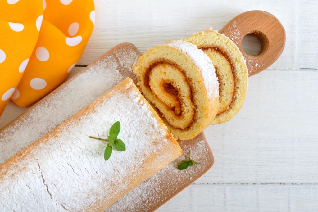 Ruladă pufoasă cu gem de caise pe un tocător