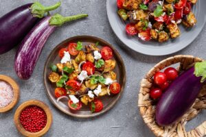 Două farfurii cu salată de vinete, roșii și brânză