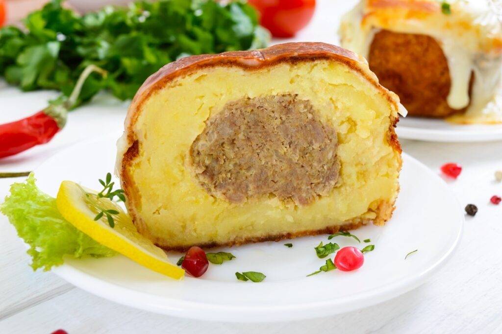 Chiftea în crustă de piure de cartofi, gratinată cu cașcaval, secționată