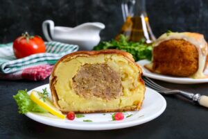 Chiftea în crustă de piure de cartofi, gratinată cu cașcaval, secționată
