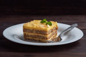 Porție de prăjitură cu nuci și cremă de gălbenușuri