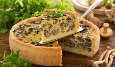 Tartă cu ciuperci și aluat fraged porționată și decorată cu pătrunjel verde