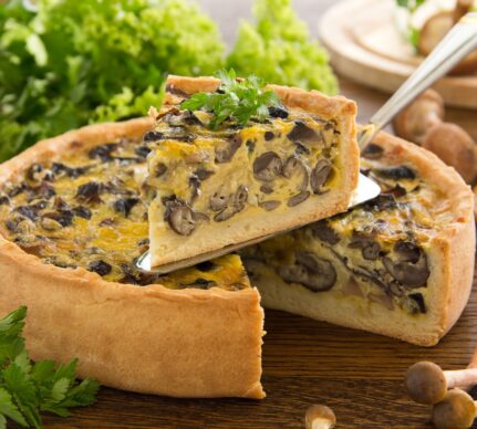 Tartă cu ciuperci și aluat fraged porționată și decorată cu pătrunjel verde